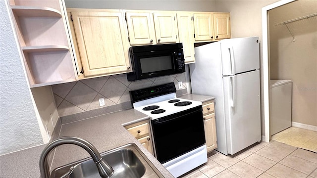 1375 Lake Shadow Cir Unit 11203, Maitland, FL 32751 - kitchen featuring black microwave, open shelves, range with electric stovetop, freestanding refrigerator, and washing machine and clothes dryer