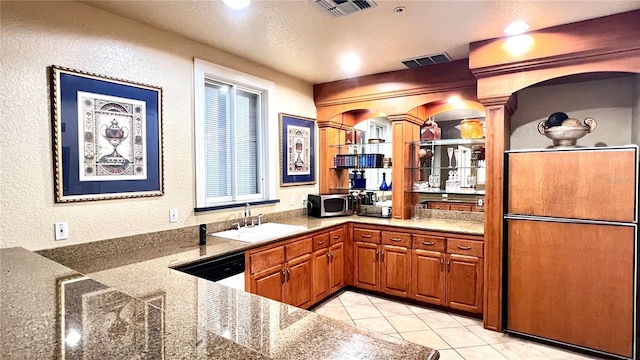 1375 Lake Shadow Cir Unit 11203, Maitland, FL 32751 - kitchen with stainless steel microwave, dishwasher, a textured wall, light tile patterned floors, and brown cabinetry