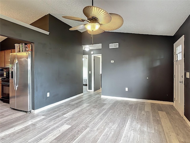 1510 Chatsworth Ave, Deltona, FL 32738 - unfurnished living room featuring ceiling fan, vaulted ceiling, light wood-style flooring, and a textured ceiling