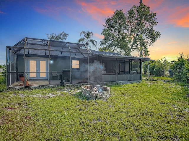 1510 Chatsworth Ave, Deltona, FL 32738 - back of property featuring a fire pit, a yard, glass enclosure, and french doors