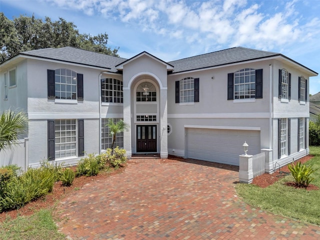 1121 Needlewood Loop, Oviedo, FL 32765 - neoclassical / greek revival house featuring stucco siding, a garage, decorative driveway, and roof with shingles