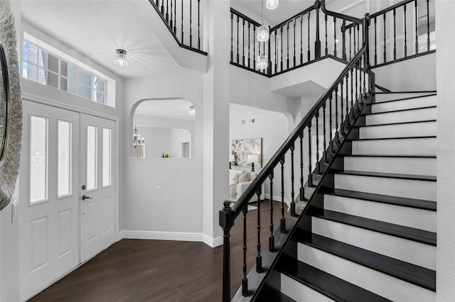 1121 Needlewood Loop, Oviedo, FL 32765 - entrance foyer featuring a chandelier, dark wood-style flooring, a high ceiling, stairs, and arched walkways