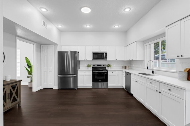 1121 Needlewood Loop, Oviedo, FL 32765 - kitchen with appliances with stainless steel finishes, light countertops, recessed lighting, white cabinets, and dark wood-type flooring