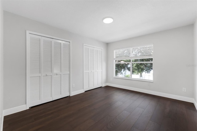 1121 Needlewood Loop, Oviedo, FL 32765 - unfurnished bedroom with multiple closets and dark wood-style floors