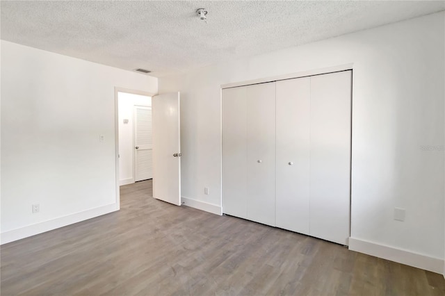 175 Springwood Cir Unit C, Longwood, FL 32750 - unfurnished bedroom with wood finished floors, a textured ceiling, and a closet