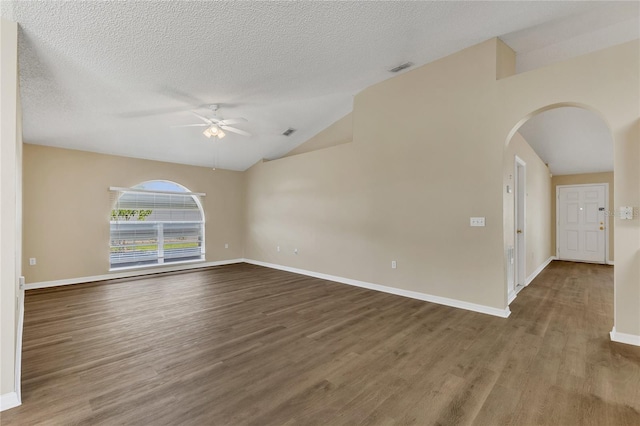 1617 Fairlight St NW, Palm Bay, FL 32907 - empty room with a ceiling fan, arched walkways, wood finished floors, lofted ceiling, and a textured ceiling