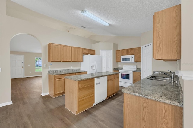 1617 Fairlight St NW, Palm Bay, FL 32907 - kitchen with white appliances, lofted ceiling, light stone counters, arched walkways, and a center island