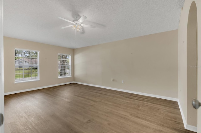 1617 Fairlight St NW, Palm Bay, FL 32907 - empty room with ceiling fan, wood finished floors, a textured ceiling, and arched walkways