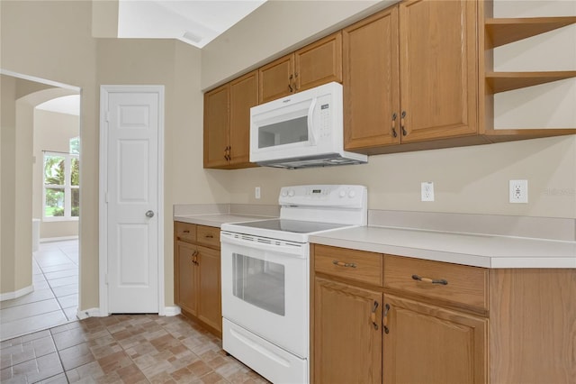 2408 Groveway Dr, Valrico, FL 33596 - kitchen with white appliances, arched walkways, light countertops, open shelves, and brown cabinetry