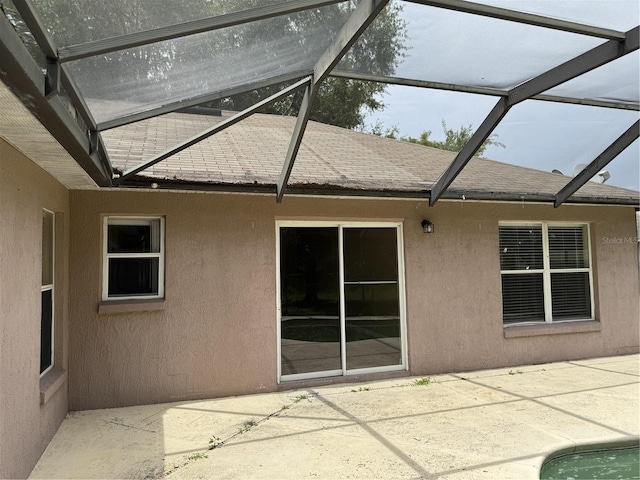 2116 New Victor Rd, Ocoee, FL 34761 - rear view of house featuring a patio area, stucco siding, roof with shingles, and a lanai