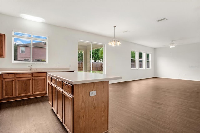 13510 Copper Belly Ct, Riverview, FL 33569 - kitchen with dark wood-style floors, light countertops, a chandelier, brown cabinets, and a center island
