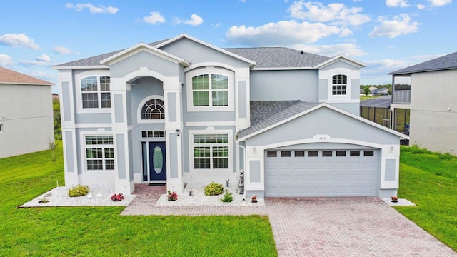 5209 Cape Hatteras Dr, Clermont, FL 34714 - traditional-style house featuring a garage, decorative driveway, stucco siding, and a front yard