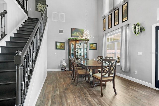 5209 Cape Hatteras Dr, Clermont, FL 34714 - dining area featuring dark wood-style floors, stairway, a high ceiling, and a chandelier