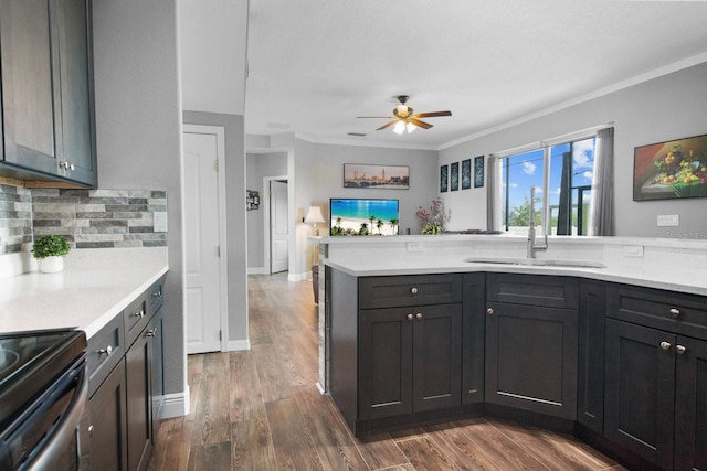 5209 Cape Hatteras Dr, Clermont, FL 34714 - kitchen with light countertops, ceiling fan, range with electric cooktop, decorative backsplash, and ornamental molding