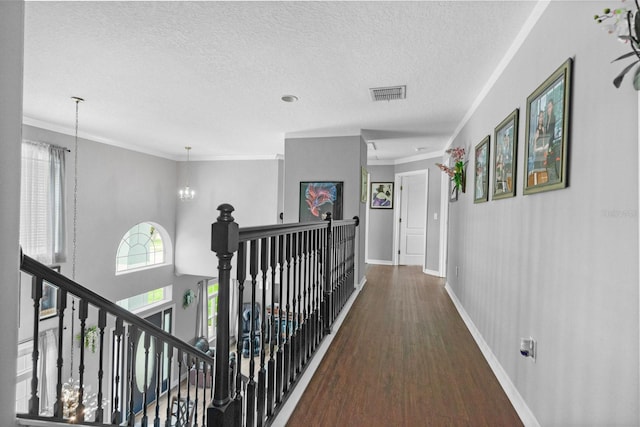 5209 Cape Hatteras Dr, Clermont, FL 34714 - corridor with wood finished floors, a textured ceiling, crown molding, a chandelier, and an upstairs landing