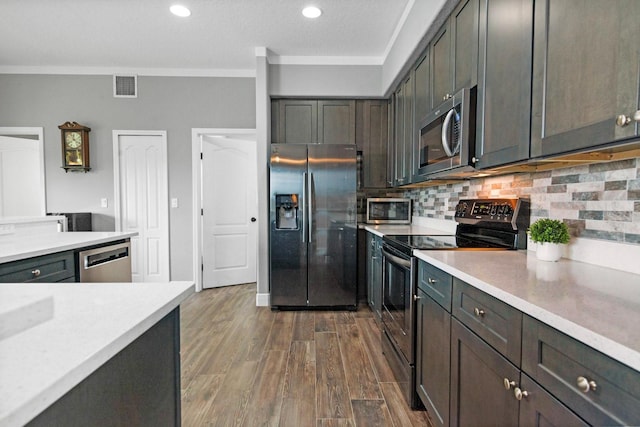 5209 Cape Hatteras Dr, Clermont, FL 34714 - kitchen featuring appliances with stainless steel finishes, crown molding, light countertops, tasteful backsplash, and recessed lighting