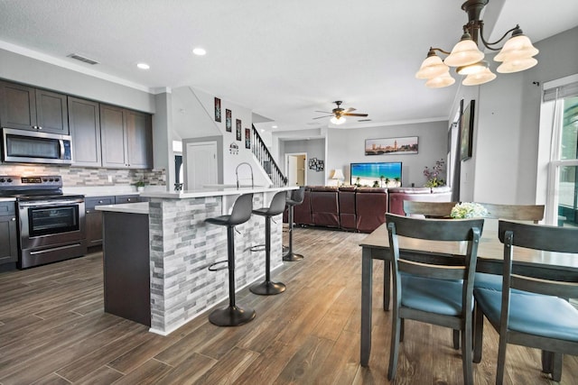 5209 Cape Hatteras Dr, Clermont, FL 34714 - kitchen featuring stainless steel appliances, light countertops, tasteful backsplash, a ceiling fan, and dark wood-style floors