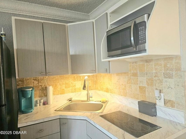3501 S Atlantic Ave Unit 5020, Daytona Beach, FL 32118 - kitchen with stainless steel microwave, black electric cooktop, gray cabinets, tasteful backsplash, and light countertops