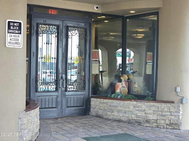 3501 S Atlantic Ave Unit 5020, Daytona Beach, FL 32118 - doorway to property with french doors, stucco siding, and a surveillance system