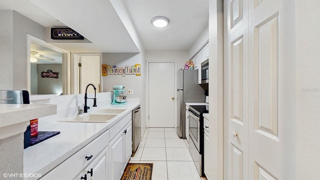 3012 Parkway Blvd Unit 203, Kissimmee, FL 34747 - kitchen featuring appliances with stainless steel finishes, white cabinetry, light countertops, and light tile patterned floors