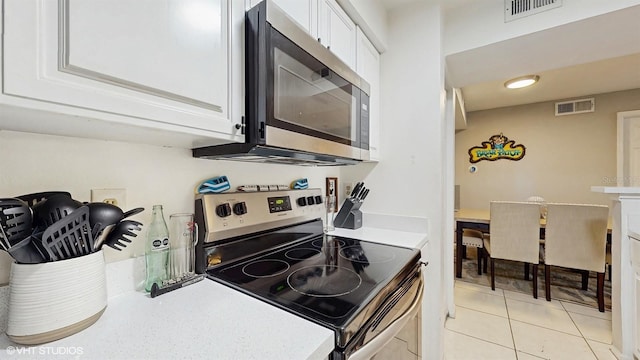 3012 Parkway Blvd Unit 203, Kissimmee, FL 34747 - kitchen featuring stainless steel appliances, white cabinets, light countertops, and light tile patterned floors