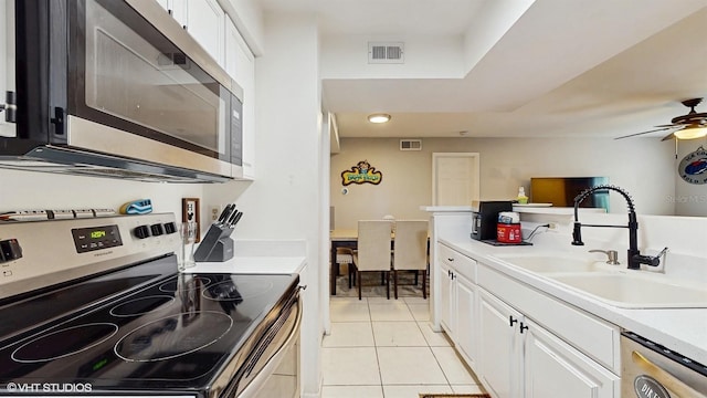 3012 Parkway Blvd Unit 203, Kissimmee, FL 34747 - kitchen featuring appliances with stainless steel finishes, light tile patterned floors, white cabinetry, light countertops, and ceiling fan