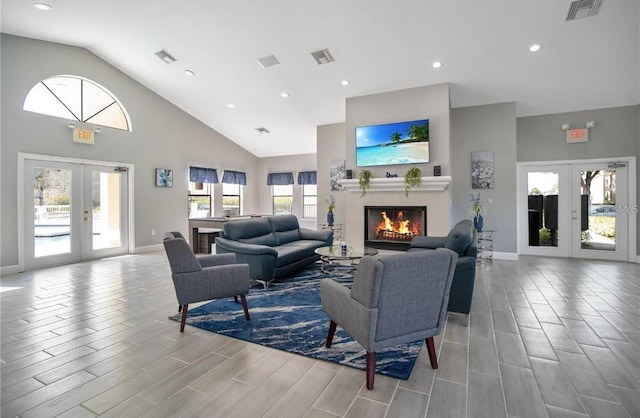 3012 Parkway Blvd Unit 203, Kissimmee, FL 34747 - living room with french doors, a warm lit fireplace, high vaulted ceiling, wood tiled floors, and recessed lighting