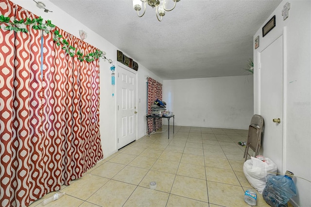 1831 Wilton Ave, Orlando, FL 32805 - tiled empty room with a textured ceiling and a chandelier