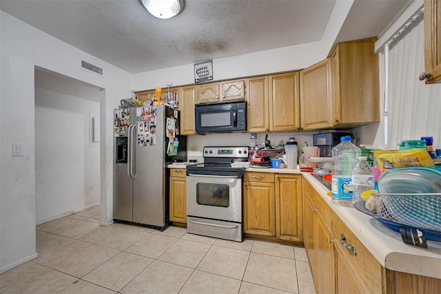 1831 Wilton Ave, Orlando, FL 32805 - kitchen with stainless steel appliances, light countertops, a textured ceiling, and light tile patterned flooring