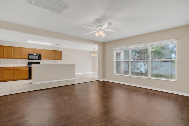 316 Crichton St, Ruskin, FL 33570 - unfurnished living room featuring light wood finished floors, ceiling fan, and a chandelier