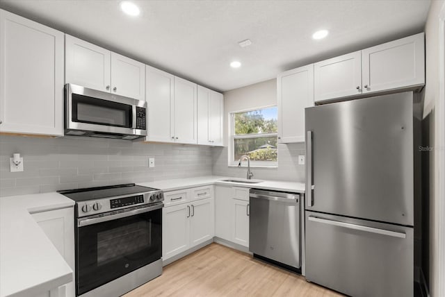 213 Flagler Ave, Edgewater, FL 32132 - kitchen featuring appliances with stainless steel finishes, light countertops, white cabinets, light wood-style flooring, and recessed lighting