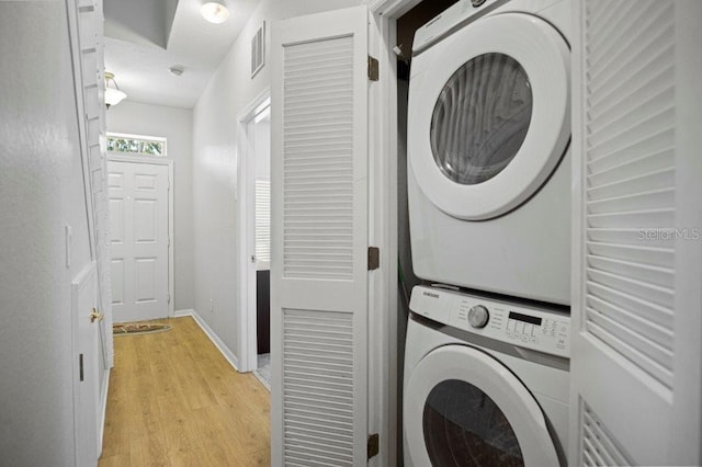 2426 Caravelle Cir, Kissimmee, FL 34746 - laundry area with stacked washer / drying machine and light wood finished floors