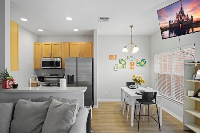 2426 Caravelle Cir, Kissimmee, FL 34746 - kitchen with stainless steel appliances, light wood-type flooring, recessed lighting, a chandelier, and open floor plan