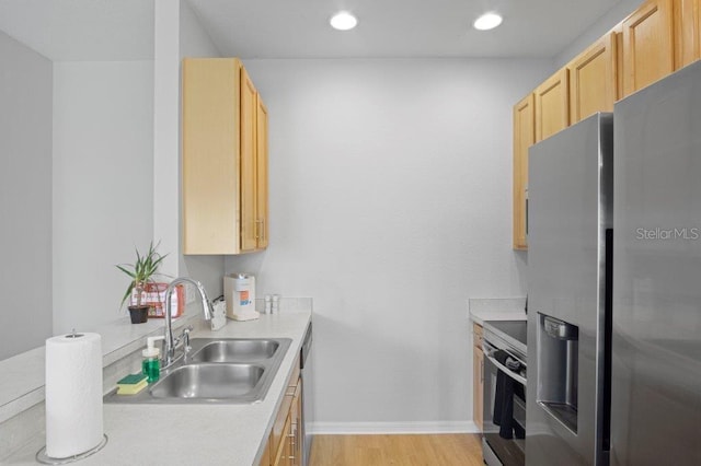2426 Caravelle Cir, Kissimmee, FL 34746 - kitchen with stainless steel appliances, light brown cabinetry, light countertops, light wood-style flooring, and recessed lighting