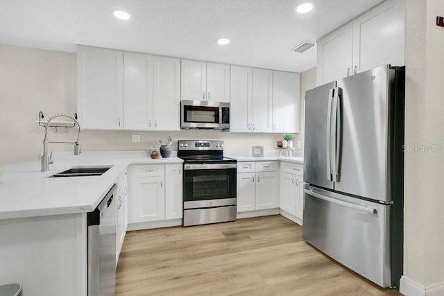 2318 Inagua Way, Winter Park, FL 32792 - kitchen featuring stainless steel appliances, white cabinets, recessed lighting, light countertops, and light wood-style floors
