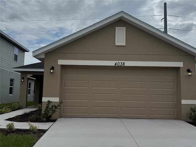 4038 Sagefield Dr, Harmony, FL 34773 - view of front facade featuring stucco siding, driveway, and a garage