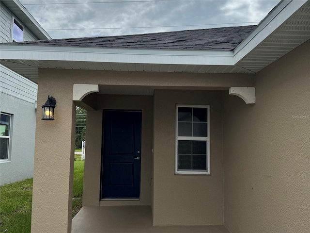 4038 Sagefield Dr, Harmony, FL 34773 - view of exterior entry with stucco siding and a shingled roof