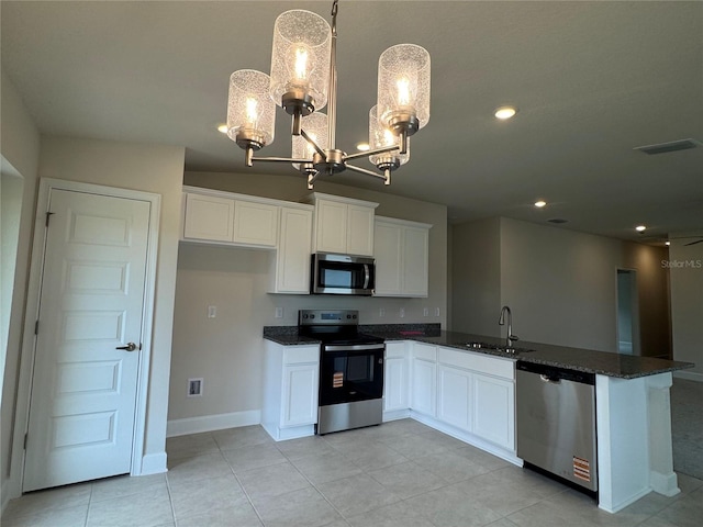 4038 Sagefield Dr, Harmony, FL 34773 - kitchen featuring stainless steel appliances, a chandelier, white cabinetry, a peninsula, and dark stone counters