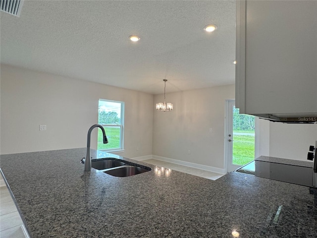 4038 Sagefield Dr, Harmony, FL 34773 - kitchen with dark stone countertops, a textured ceiling, a chandelier, recessed lighting, and pendant lighting