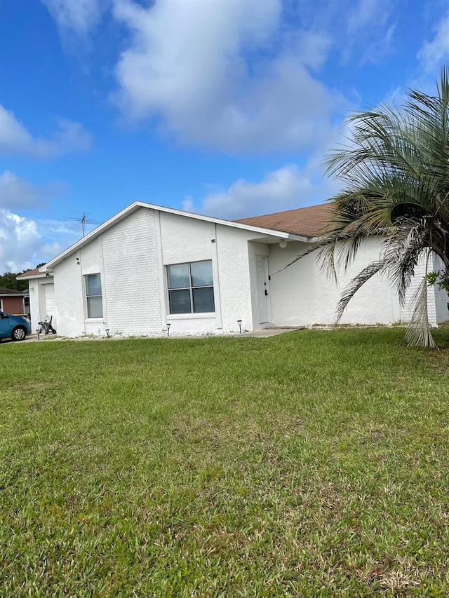 532 Koala Dr, Kissimmee, FL 34759 - view of property exterior featuring stucco siding, a yard, and a garage