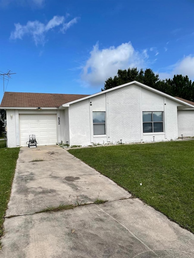 532 Koala Dr, Kissimmee, FL 34759 - view of front of property with a front lawn, a garage, concrete driveway, and stucco siding