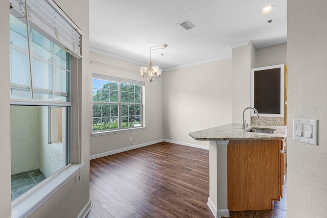 4881 Cypress Woods Dr Unit 3203, Orlando, FL 32811 - kitchen featuring light stone counters, brown cabinetry, dark wood finished floors, a chandelier, and crown molding