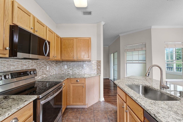 4881 Cypress Woods Dr Unit 3203, Orlando, FL 32811 - kitchen featuring appliances with stainless steel finishes, tasteful backsplash, crown molding, a textured ceiling, and light stone countertops