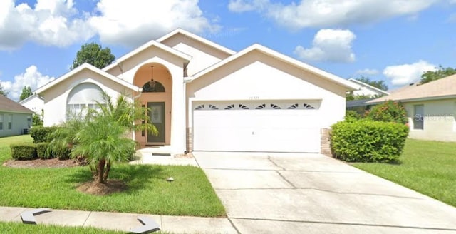 15935 Heron Hill St, Clermont, FL 34714 - ranch-style house with an attached garage, concrete driveway, a front lawn, and stucco siding