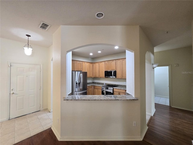 3001 Laurel Run Ln Unit 203, Kissimmee, FL 34741 - kitchen with stainless steel appliances, arched walkways, wood finished floors, recessed lighting, and decorative light fixtures