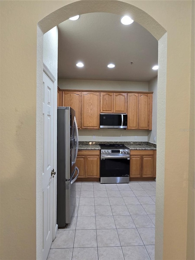 3001 Laurel Run Ln Unit 203, Kissimmee, FL 34741 - kitchen with stainless steel appliances, arched walkways, recessed lighting, brown cabinets, and a textured wall