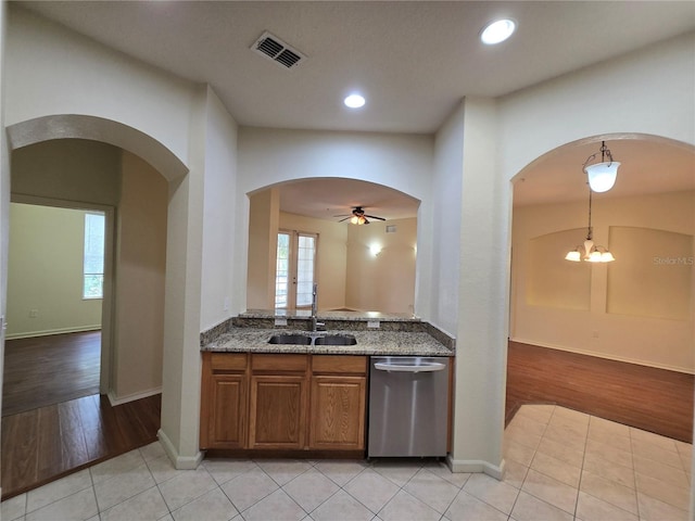 3001 Laurel Run Ln Unit 203, Kissimmee, FL 34741 - kitchen with dishwasher, arched walkways, dark stone countertops, brown cabinets, and ceiling fan