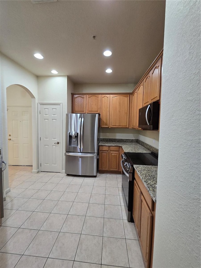 3001 Laurel Run Ln Unit 203, Kissimmee, FL 34741 - kitchen with stainless steel fridge with ice dispenser, range with electric stovetop, black microwave, arched walkways, and recessed lighting