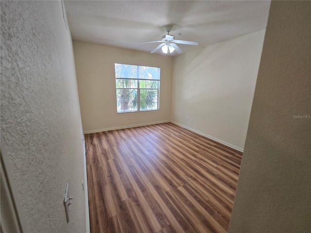 3001 Laurel Run Ln Unit 203, Kissimmee, FL 34741 - empty room with wood finished floors, ceiling fan, and a textured wall