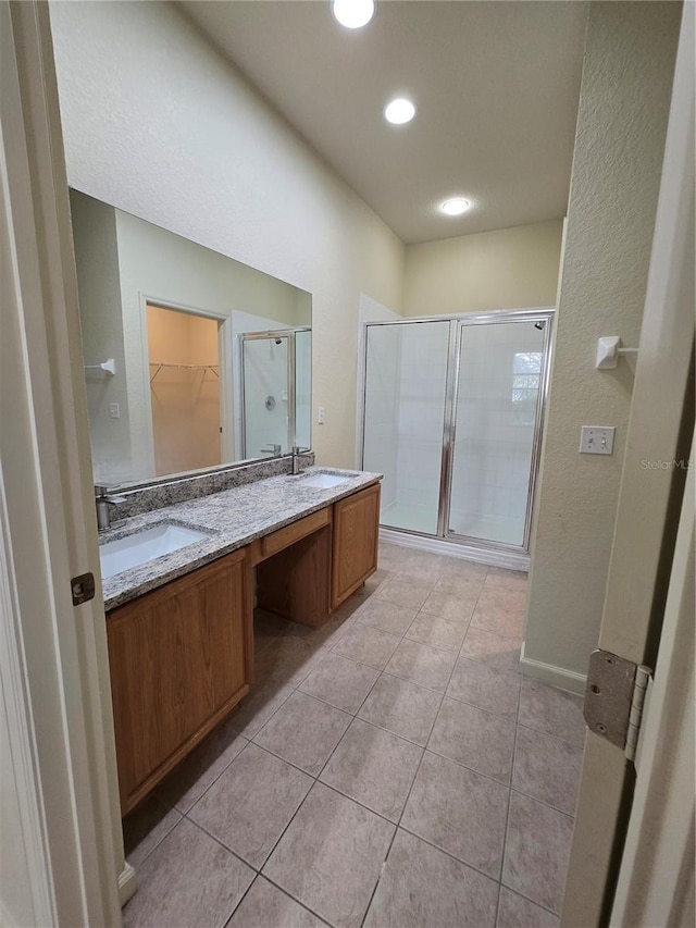 3001 Laurel Run Ln Unit 203, Kissimmee, FL 34741 - full bath with a shower stall, double vanity, tile patterned floors, a walk in closet, and a textured wall